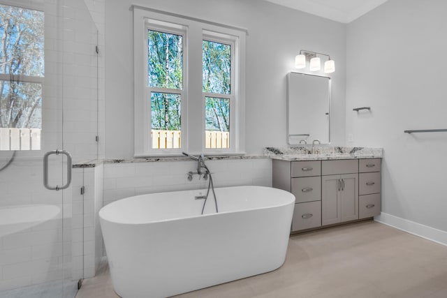 bathroom with plus walk in shower, tile walls, and vanity