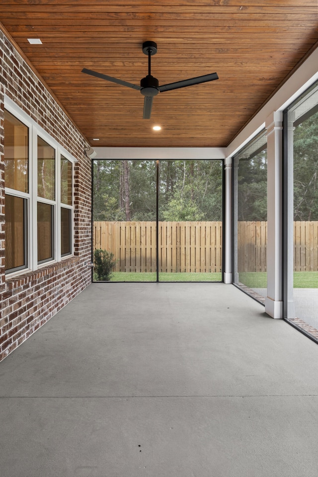 unfurnished sunroom featuring wooden ceiling and ceiling fan