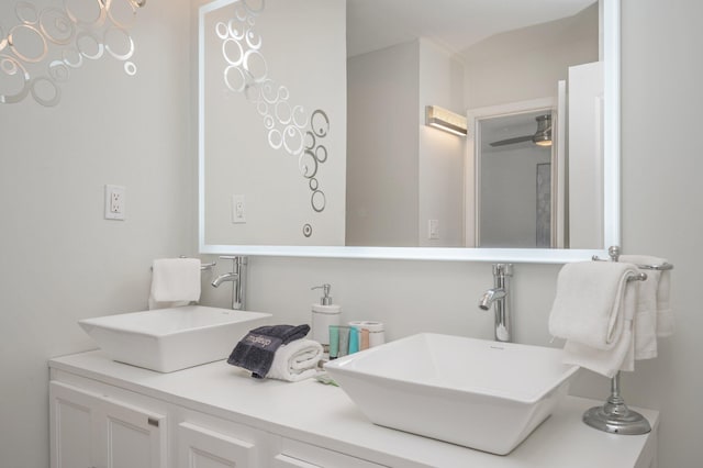 bathroom featuring oversized vanity, ceiling fan, and double sink