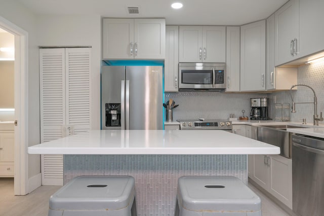 kitchen with tasteful backsplash, a center island, stainless steel appliances, and a breakfast bar area