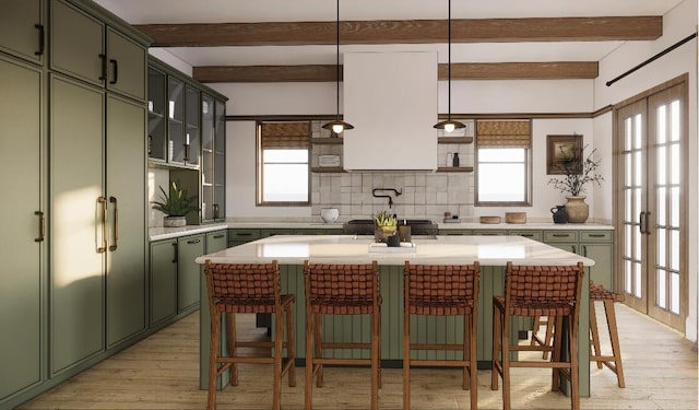 kitchen with tasteful backsplash, a kitchen breakfast bar, pendant lighting, a center island, and light wood-type flooring