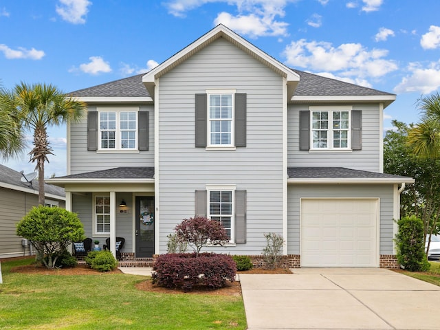 view of property featuring a front yard and a garage