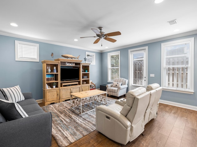 living room featuring ornamental molding, a healthy amount of sunlight, dark hardwood / wood-style flooring, and ceiling fan