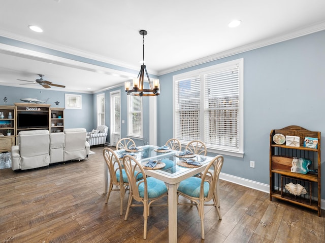 dining area featuring ceiling fan with notable chandelier, dark wood-type flooring, and crown molding