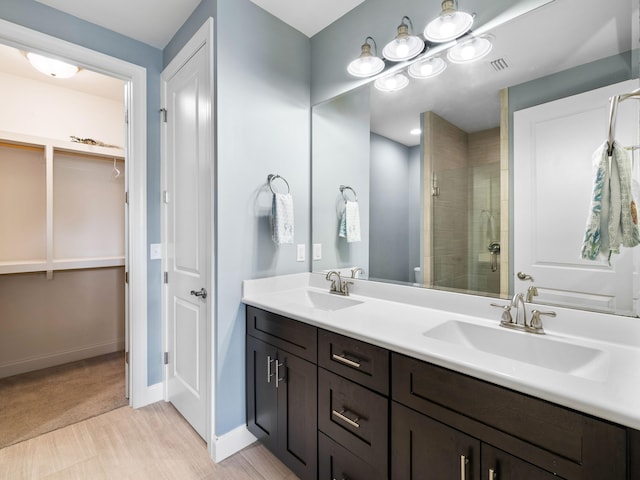 bathroom featuring double sink, a shower with door, tile flooring, and large vanity