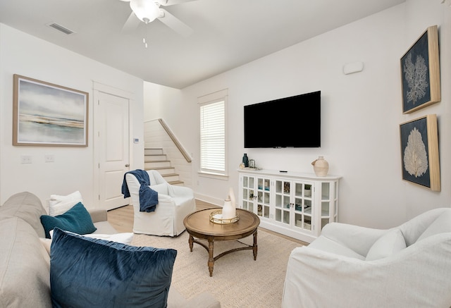 living room with light hardwood / wood-style floors and ceiling fan