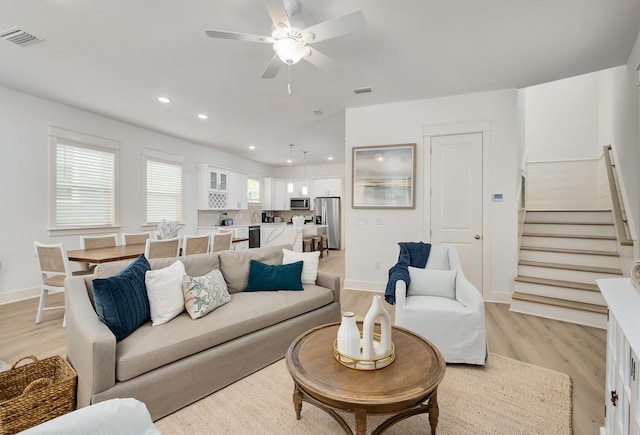 living room featuring light hardwood / wood-style flooring and ceiling fan