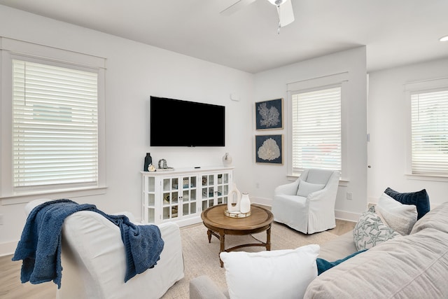 living room with light hardwood / wood-style flooring and ceiling fan