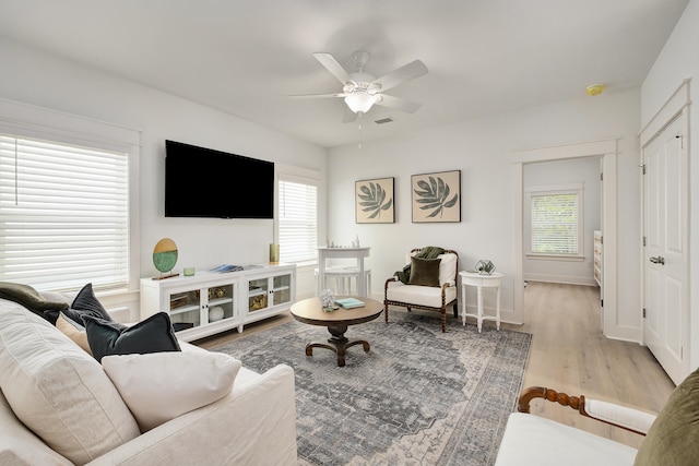 living room with light hardwood / wood-style flooring and ceiling fan