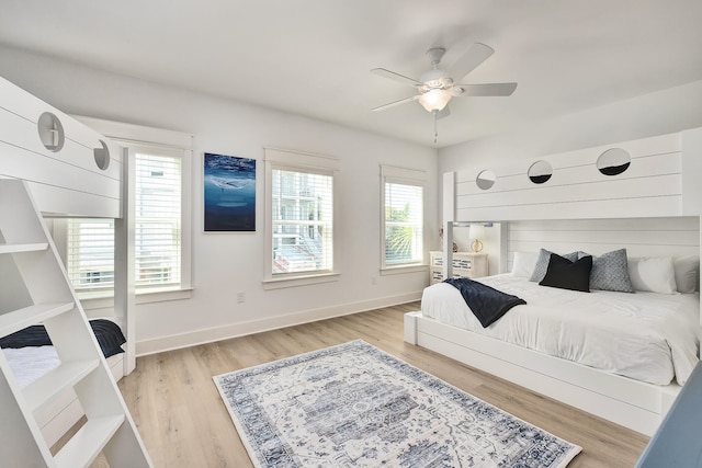 bedroom featuring light hardwood / wood-style floors, ceiling fan, and multiple windows