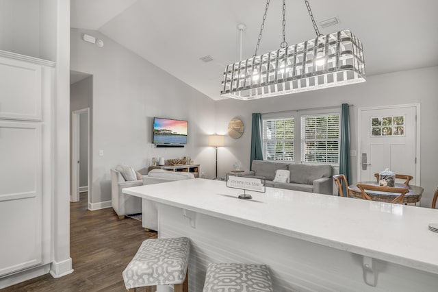 dining space with dark hardwood / wood-style floors, high vaulted ceiling, and a notable chandelier