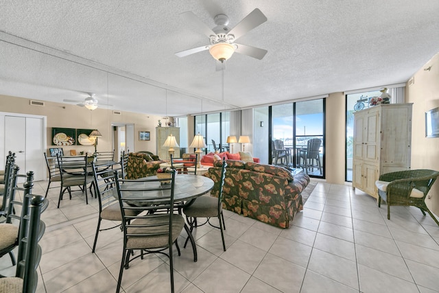 dining area with a wall of windows, a textured ceiling, ceiling fan, and light tile flooring