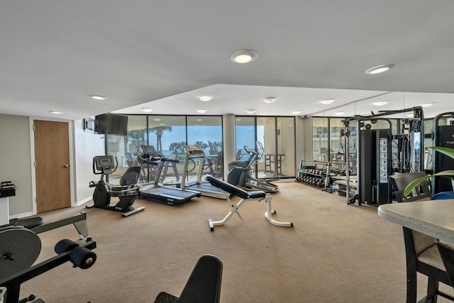 workout area featuring floor to ceiling windows and light colored carpet