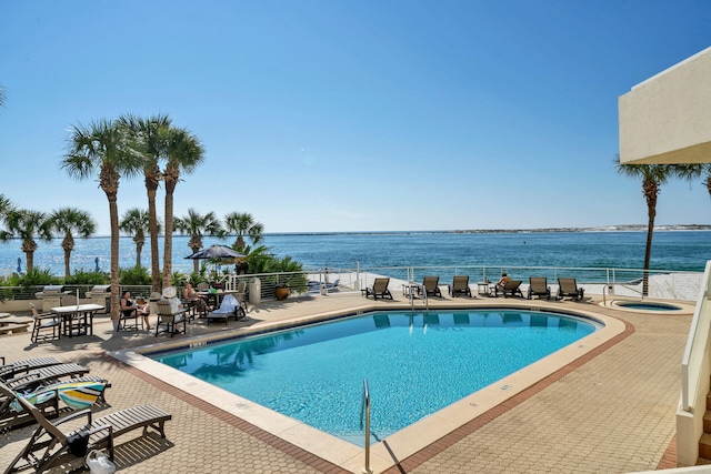 view of swimming pool featuring a patio area and a water view