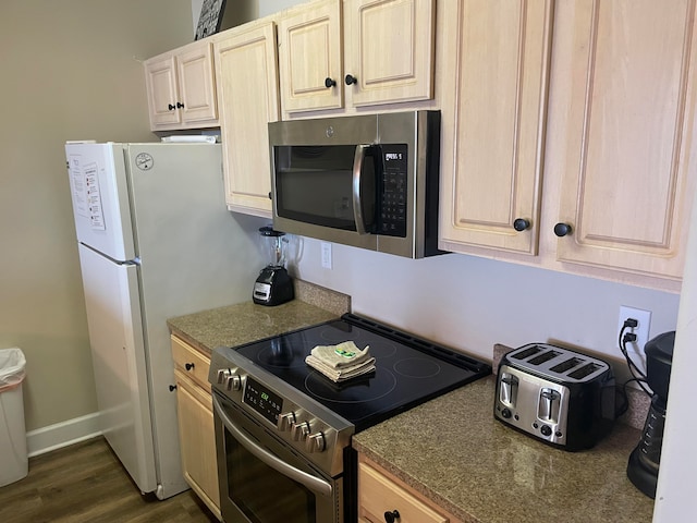 kitchen with light brown cabinetry, dark hardwood / wood-style flooring, and stainless steel appliances