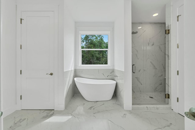 full bath featuring a marble finish shower, wainscoting, marble finish floor, a freestanding tub, and recessed lighting