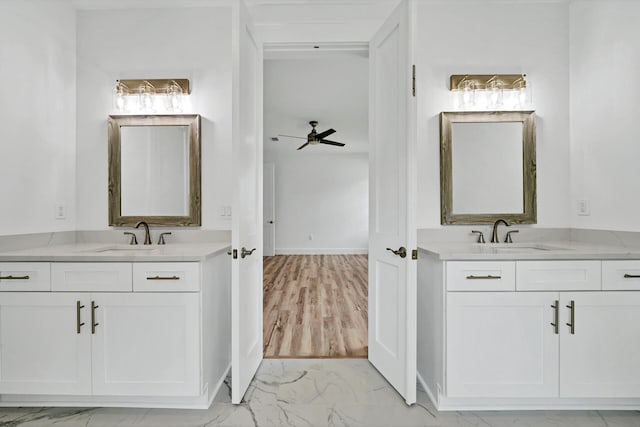 bathroom featuring marble finish floor, two vanities, and a sink