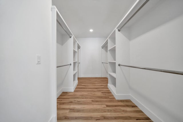 walk in closet with light hardwood / wood-style flooring