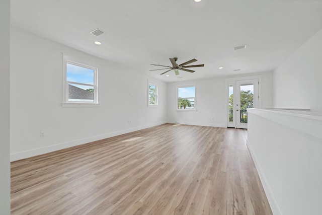 unfurnished living room with light wood-style floors, visible vents, and plenty of natural light