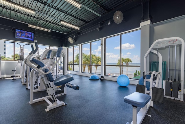 gym featuring a wealth of natural light and a water view