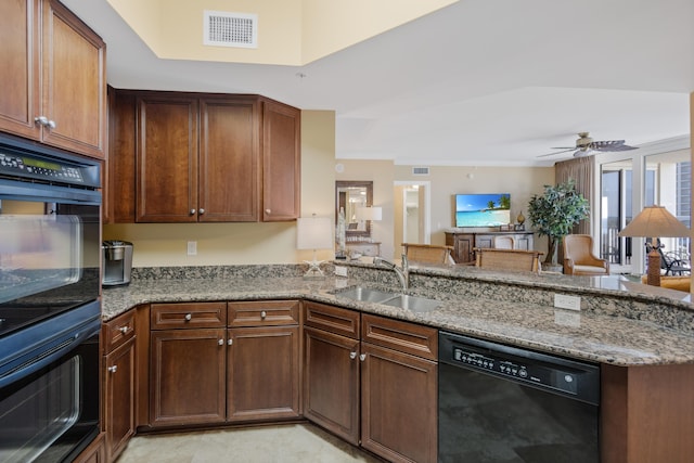 kitchen with black appliances, ceiling fan, light stone countertops, and sink