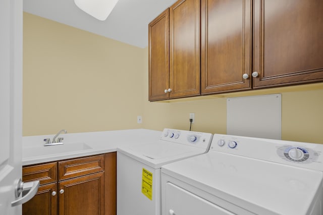 laundry room featuring washer and clothes dryer, cabinets, and sink