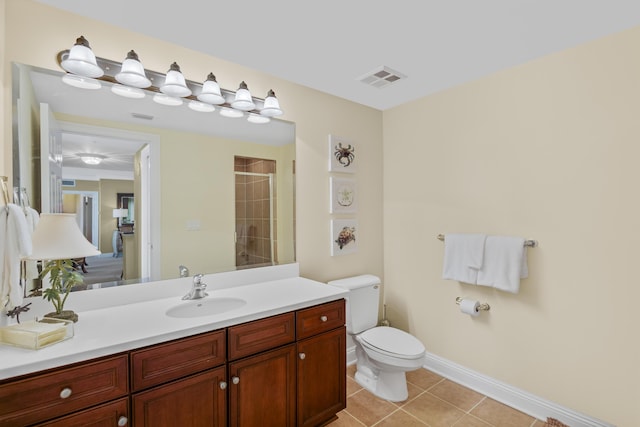 bathroom with tile patterned flooring, vanity, toilet, and walk in shower