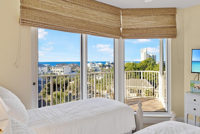 bedroom with access to exterior and a water view