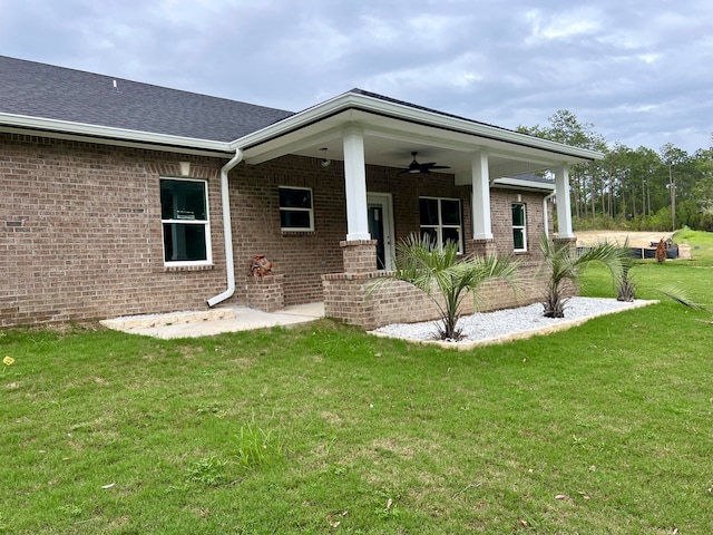 exterior space featuring ceiling fan and a lawn