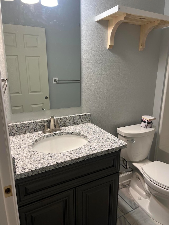 bathroom with tile patterned floors, vanity, and toilet