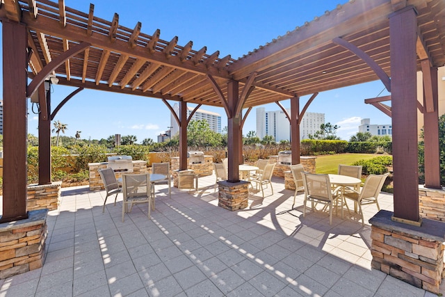 view of patio / terrace with a fire pit, an outdoor kitchen, and a pergola