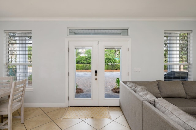 doorway to outside featuring french doors, crown molding, and light tile flooring