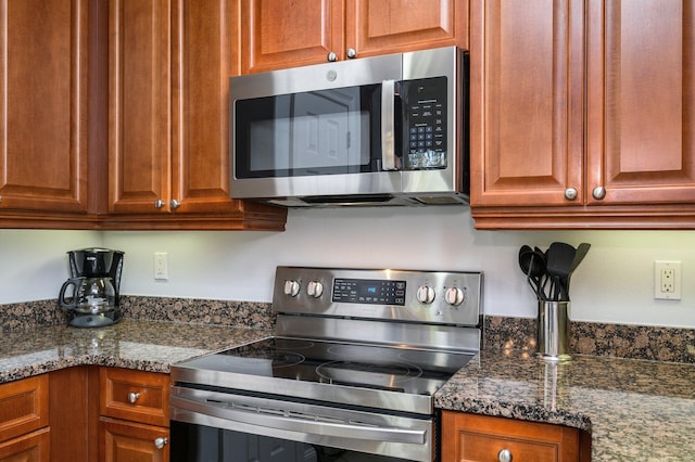 kitchen with stainless steel appliances and dark stone counters