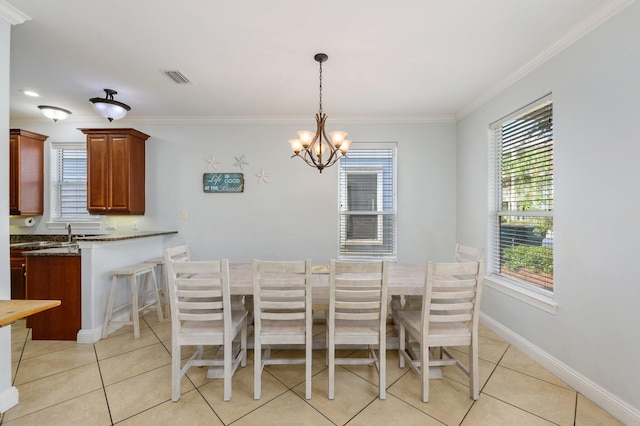 tiled dining space featuring plenty of natural light, crown molding, and an inviting chandelier