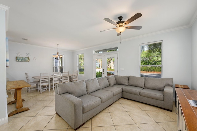 tiled living room with ornamental molding, french doors, and ceiling fan with notable chandelier