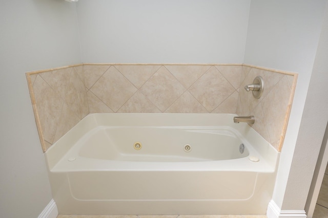 bathroom featuring a bath and tile floors