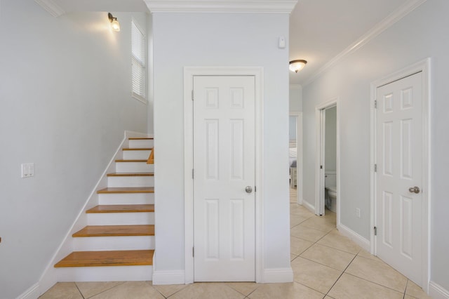 stairway with crown molding and light tile flooring