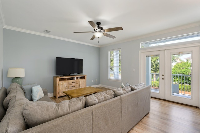 living room featuring ornamental molding, light hardwood / wood-style floors, and ceiling fan