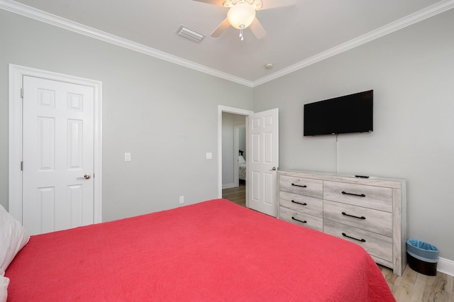 bedroom featuring light hardwood / wood-style flooring, ceiling fan, and crown molding