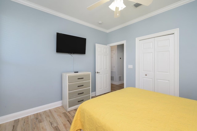 bedroom featuring ornamental molding, a closet, ceiling fan, and light hardwood / wood-style flooring