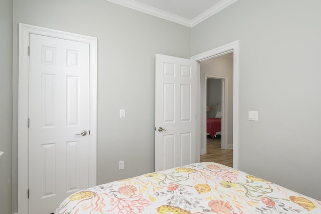 bedroom featuring hardwood / wood-style floors, a closet, and ornamental molding