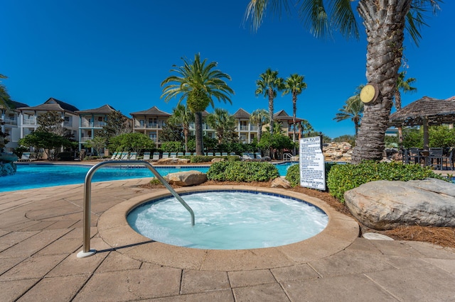 view of pool with a hot tub