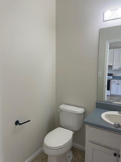 bathroom featuring vanity, toilet, and tile floors