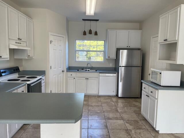 kitchen with white cabinetry, decorative light fixtures, white appliances, and light tile floors