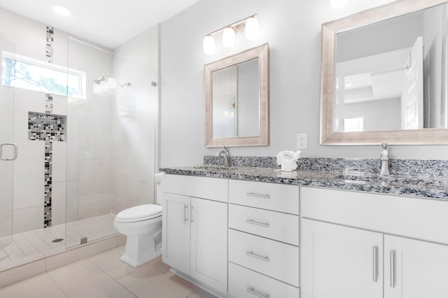 bathroom featuring plenty of natural light, toilet, tile flooring, and vanity