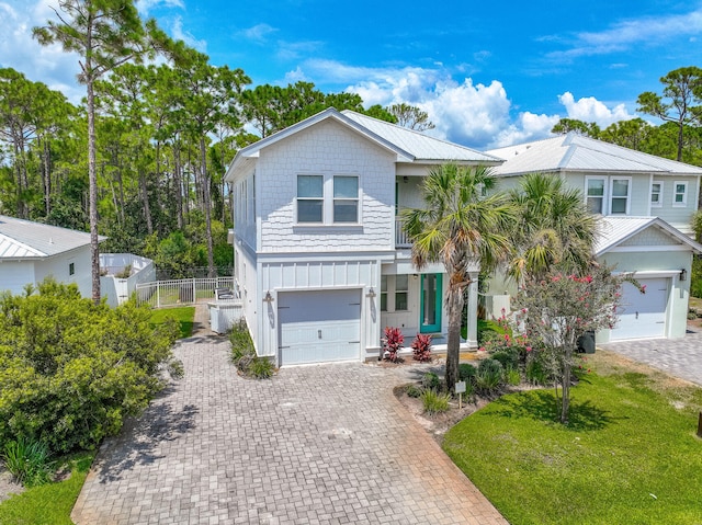 coastal inspired home with a front yard and a garage