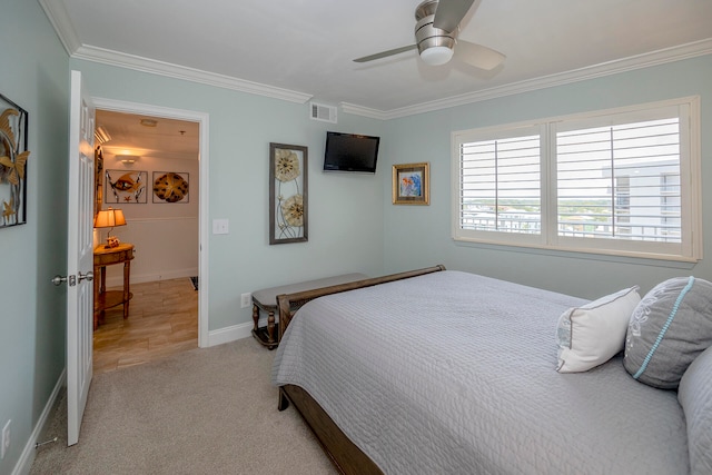 carpeted bedroom featuring ceiling fan and ornamental molding