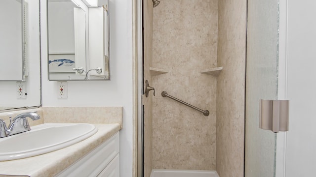 bathroom with a shower and vanity with extensive cabinet space