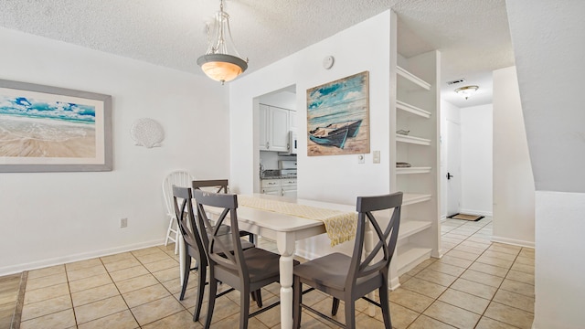 tiled dining room featuring a textured ceiling and built in features