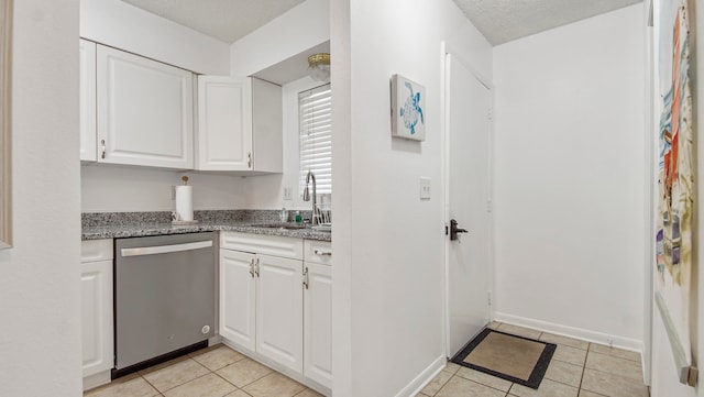 kitchen with white cabinets, sink, dishwasher, and light tile flooring